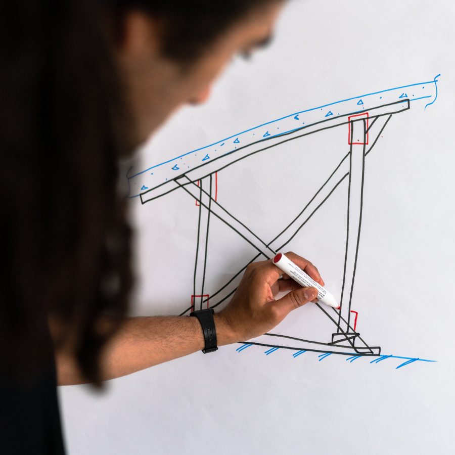 A person drawing a schematic on a whiteboard
