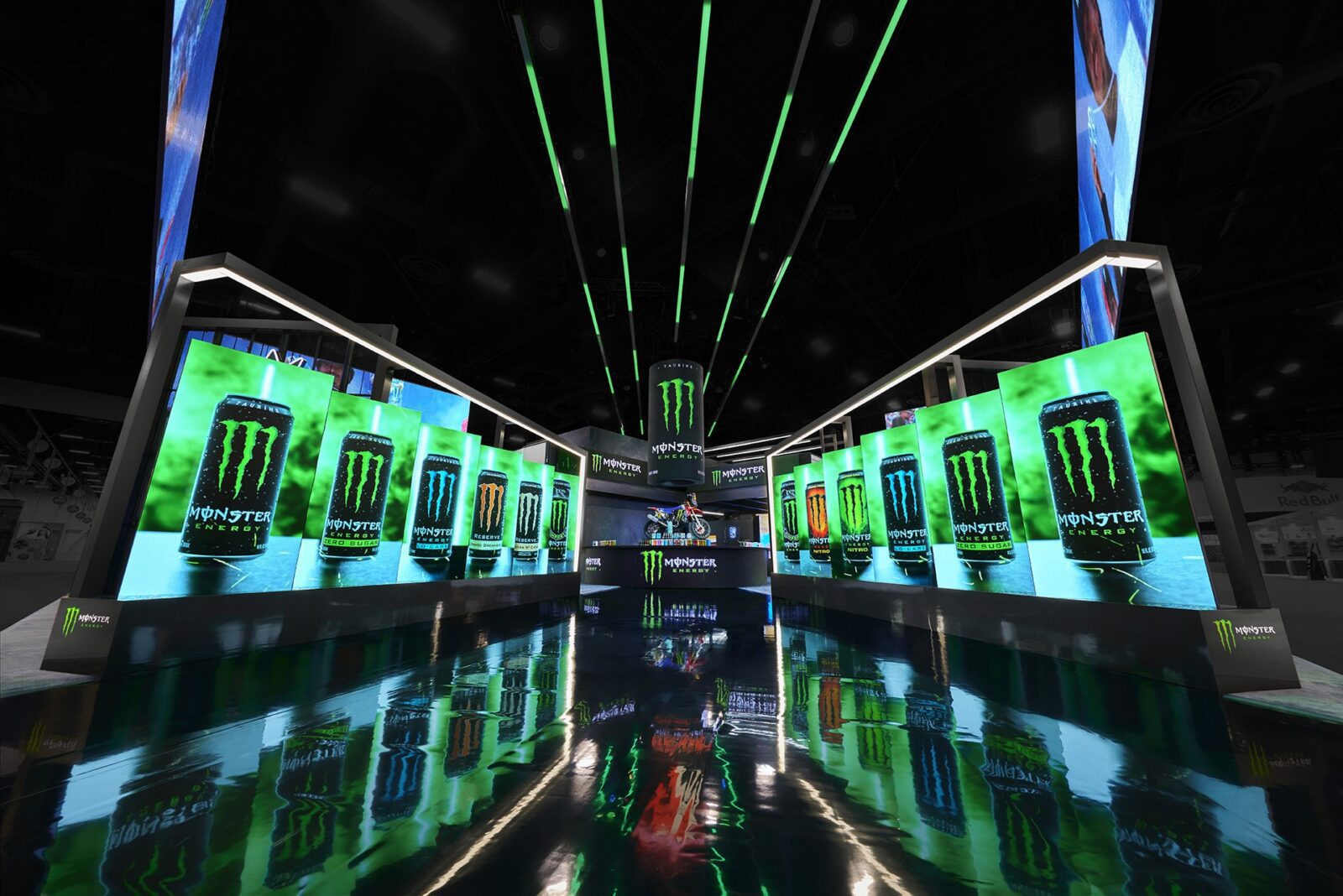 A brightly lit exhibition booth showcases multiple images of Monster Energy drink cans, with green neon lights and reflective flooring enhancing the visual impact and demonstrating innovative trade show design.